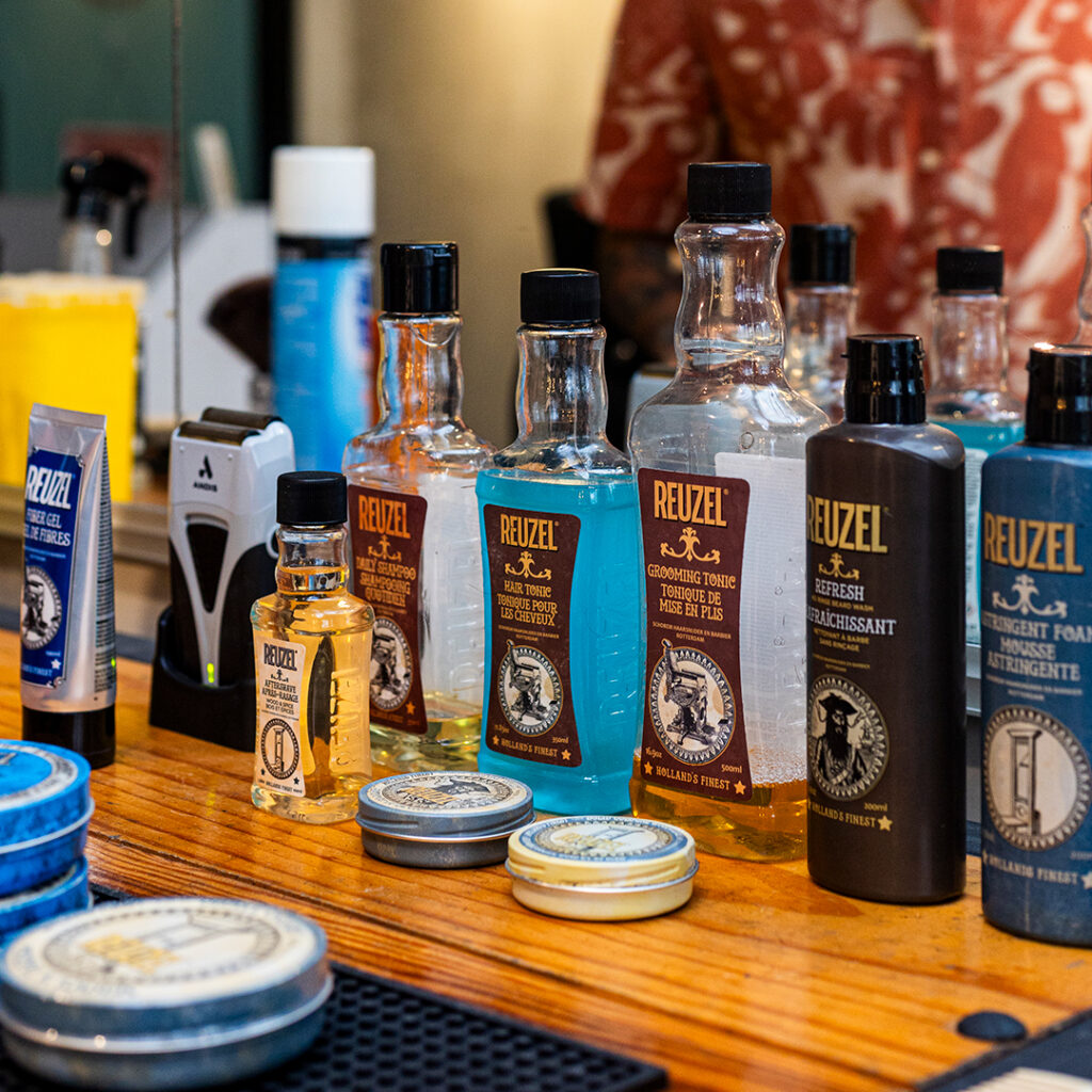 Productos Reuzel de barbería sobre una mesa de trabajo